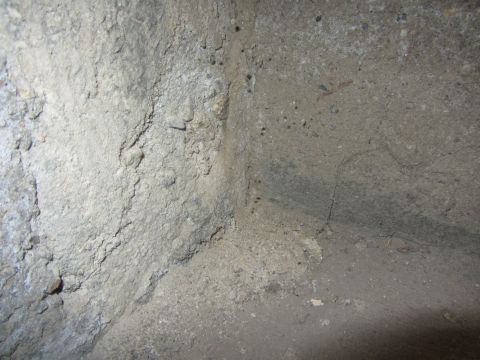 1968 Ford Mustang - Interior view of a rough concrete corner with scattered debris.