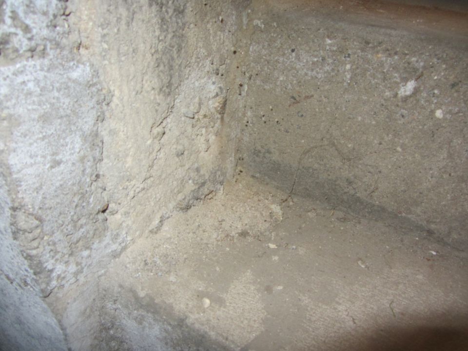 close-up of a rough concrete corner with some staining and cracks