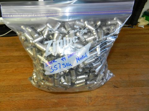 1996 Ford Bronco - A Ziploc bag filled with approximately 1000 spent 357 SIG nickel shell casings sits on a wooden surface.