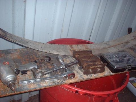 1993 Ford Bronco - Tools and a vehicle part are laid out on a workbench, possibly for repair or maintenance.
