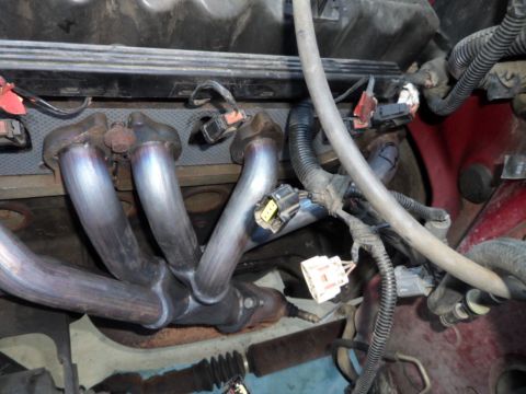 1994 Jeep Cherokee - Engine bay detail showing exhaust manifold and various electrical connectors.