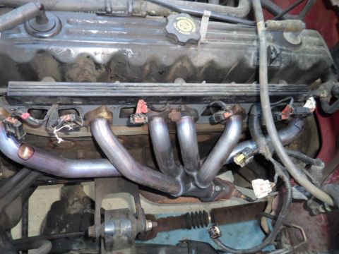 1994 Jeep Cherokee - Close-up view of a vehicle's engine bay, focusing on the exhaust manifold and associated components.