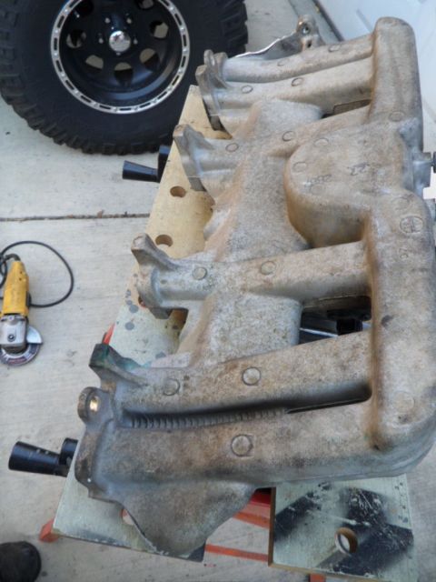 1994 Jeep Cherokee - Close-up of an intake manifold, showing casting marks and the Supermotors website logo at the bottom.