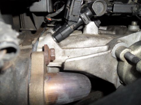 1994 Jeep Cherokee - This image shows a close-up view of engine parts, focusing on fuel injectors and a bolted exhaust connection.