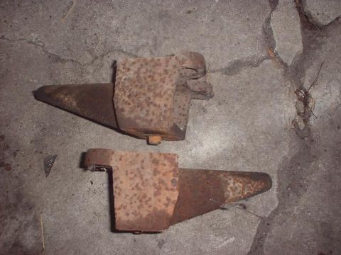 1993 Ford Bronco - Two rusty metal components are shown resting on a concrete surface.