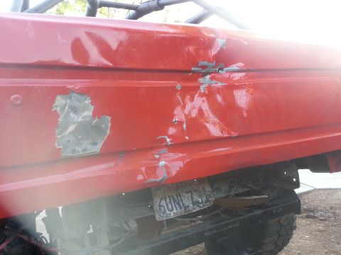 1978 Ford Bronco - Side view of a damaged red vehicle, showing extensive bodywork issues.