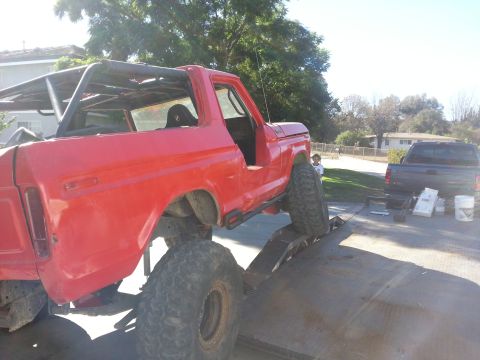 1978 Ford Bronco - Modified 1978 Ford Bronco being loaded onto a trailer, with another truck visible in the background.