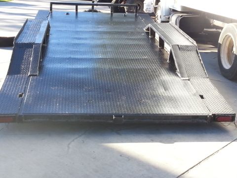 1978 Ford Bronco - A black trailer with ramps is attached to a white truck, viewed from the rear.