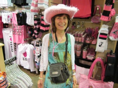 1991 Ford LTD Crown Victoria - A woman poses for a photo in a store filled with pink clothing and accessories, including a sparkly cowboy hat.