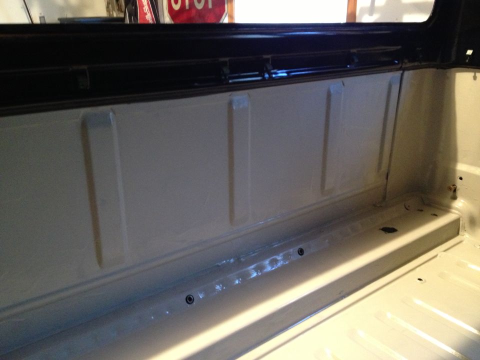 Interior of a truck bed, showing the side panel and floor