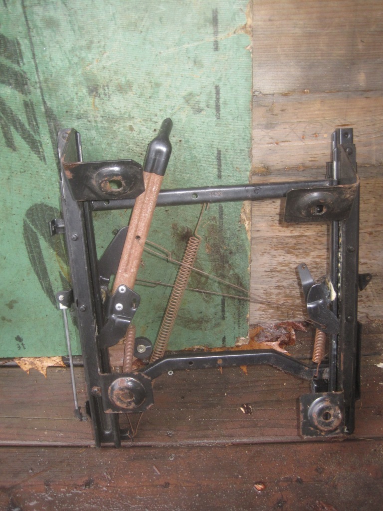 Seat frame mechanism with springs and levers, resting on wooden planks
