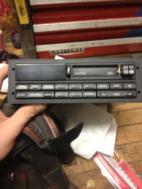 1996 Ford F-150 - A person holds a car stereo unit with a Ford logo visible on the front panel.