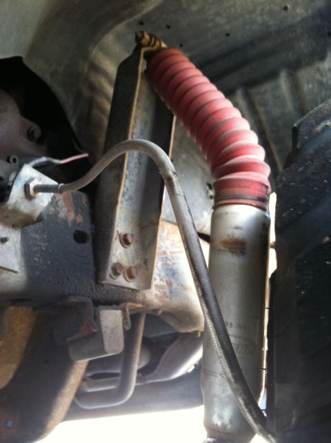 1997 Ford F-250 - Close-up view of a vehicle's suspension system, showing a shock absorber and brake line.