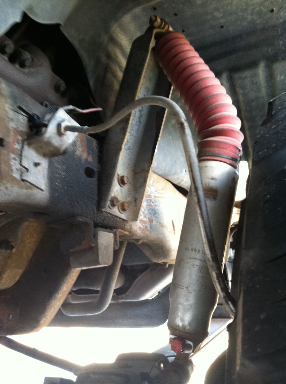 Shock absorber with red boot and visible "1999" marking