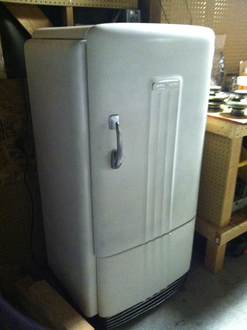 White vintage refrigerator with chrome handle and fluted panel