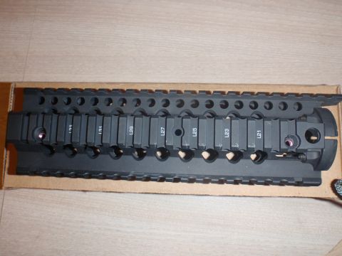 2000 Dodge 1500 - A black tactical rail system with visible numerical markings is shown against a light brown background.