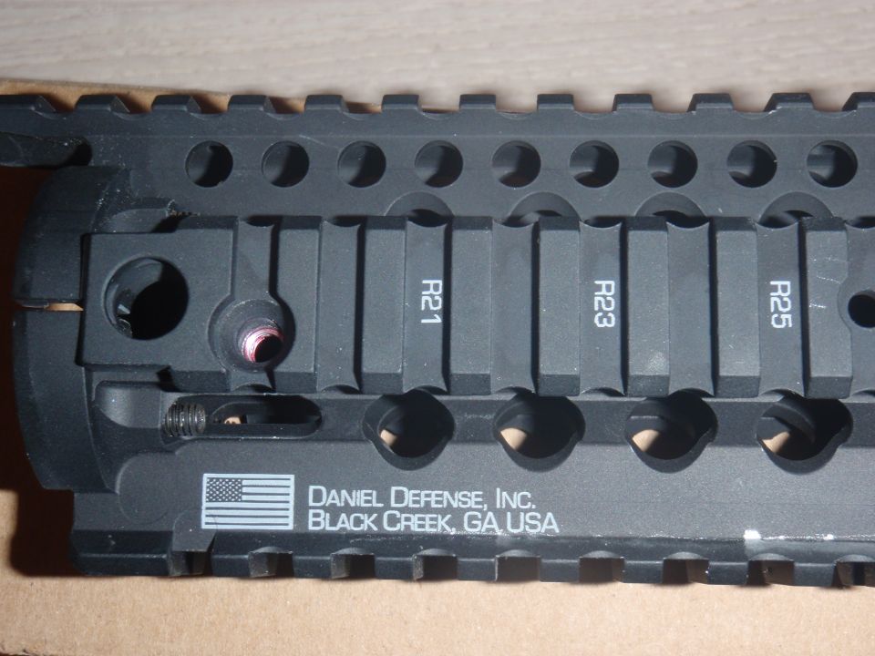 Black firearm accessory rail with R21, R23, R25 markings and Daniel Defense, Inc. text