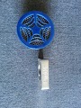 1978 Ford Bronco - A blue speaker grille is attached to a silver clip against a textured blue background.