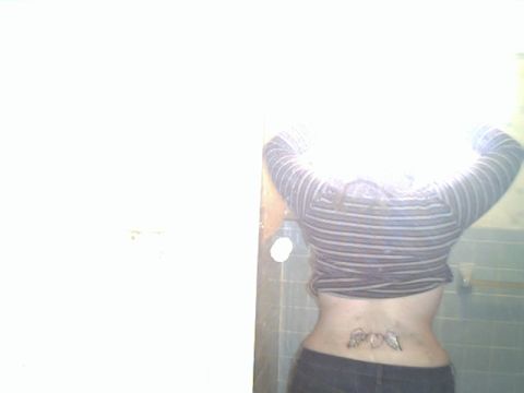 1994 Ford Crown Victoria - A person's back is visible, showing a tattoo and a striped shirt.