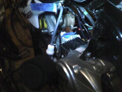 2003 Ford Crown Victoria - Close-up of engine components, including a fuel filter and wiring, with handwritten notes on blue tape.
