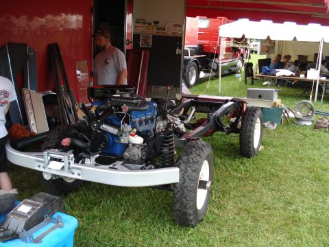 1994 Ford F-350 - Vehicle chassis and engine assembly displayed outdoors with a large truck and tent in the background.