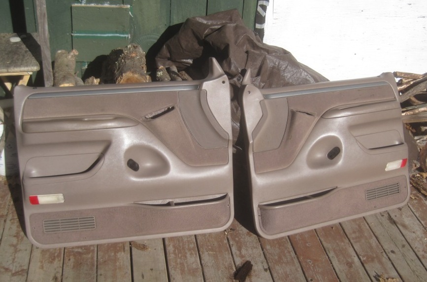 Pair of tan front door panels with speaker grilles and red reflectors
