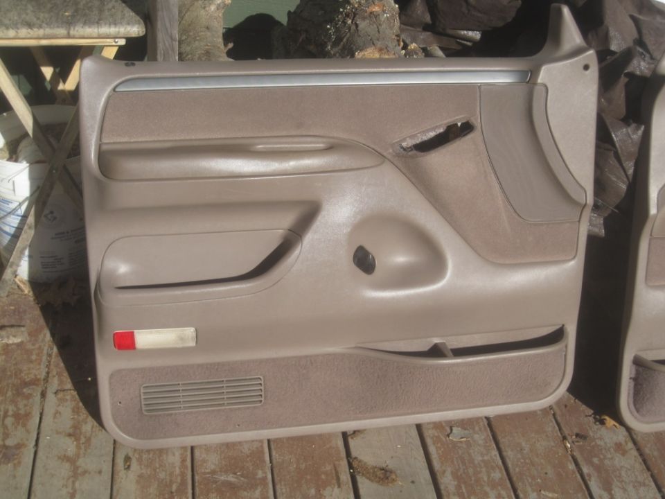 Tan Ford Bronco door panel with speaker grille and red reflector