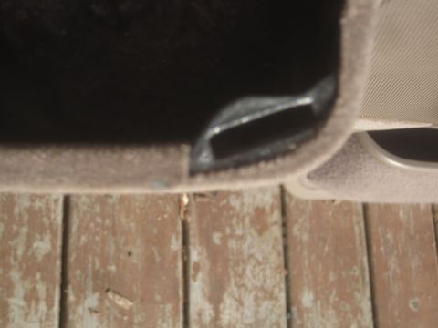 1993 Ford Bronco - Detail shot of a car's interior door handle mechanism and carpeted trim.