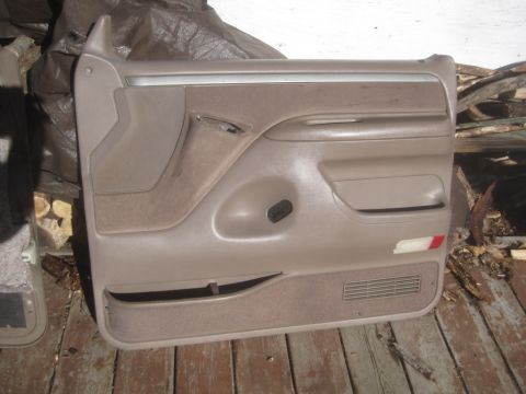 1993 Ford Bronco - A tan car door panel with fabric inserts and a speaker grille is shown.