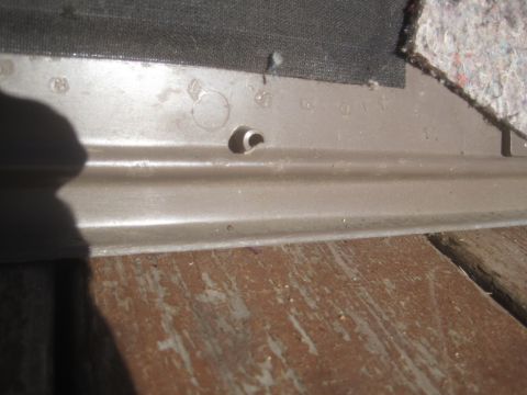 1993 Ford Bronco - This is a close-up view of a vehicle's interior trim piece, showing some of the mounting holes and fabric backing.