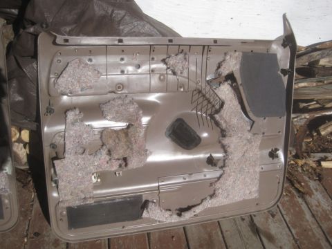 1993 Ford Bronco - Interior view of a brown car door panel with insulation removed, showing the inner workings.