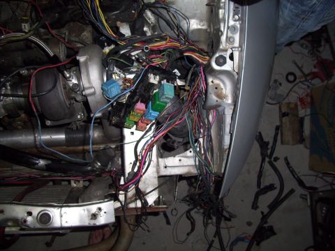1995 Ford Probe - A chaotic engine bay shows a turbocharger and a massive, unorganized wiring harness with multiple relays.