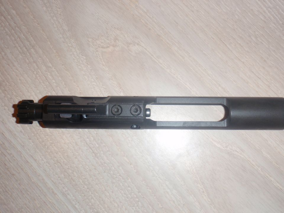 AR-15 bolt carrier group on a wooden surface