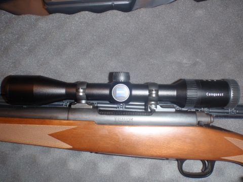 2000 Dodge 1500 - A rifle scope is mounted on a wooden stock, with visible text indicating the brand and model.