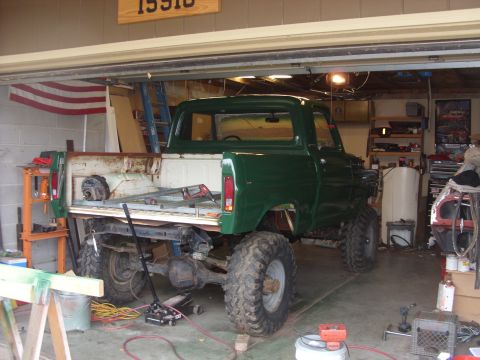 1967 Ford F-250 - Green 1967 Ford F-250 pickup truck with large tires is parked inside a garage.