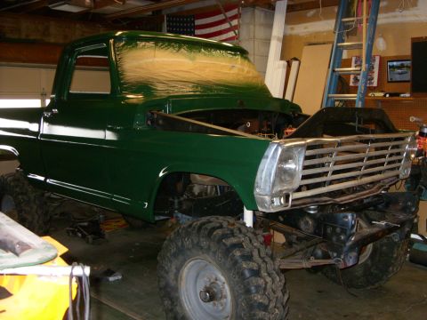 1967 Ford F-250 - Green 1967 Ford F-250 pickup truck in a garage, with hood removed and front end partially disassembled.