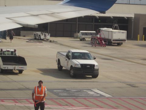 1991 Ford LTD Crown Victoria - A white Ford F-150 pickup truck is seen on an airport tarmac near an airplane wing and other service vehicles.