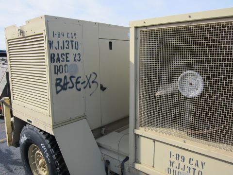 1991 Ford LTD Crown Victoria - A military generator unit is marked with unit designations and spray-painted text.