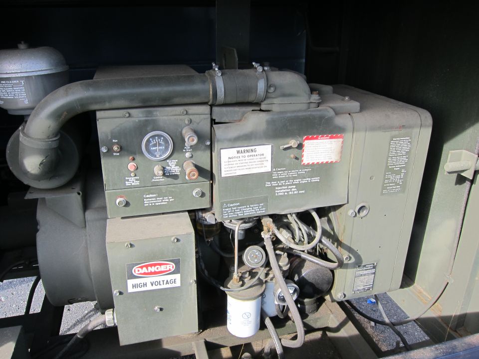 Green military generator engine with gauges and warning labels