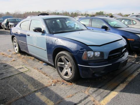 1991 Ford LTD Crown Victoria - This two-tone Dodge Charger, likely a former police vehicle, sits in a junkyard with its hood open.