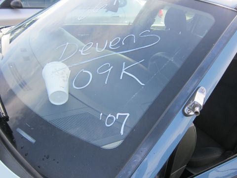 1991 Ford LTD Crown Victoria - A cup sits on a windshield with handwritten notes including 'Devens 109K' and '07'.
