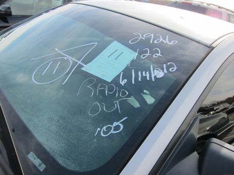 1991 Ford LTD Crown Victoria - Chalk markings on a car's windshield indicate 'RADIO OUT' and a date of 6/14/12.