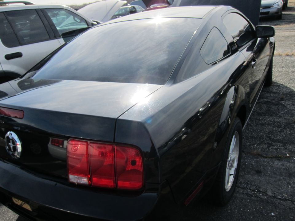 Black coupe rear quarter view. Visible taillight and wheel