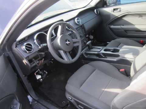 1991 Ford LTD Crown Victoria - The interior of a car is shown, gray cloth seats and a black dashboard with a steering wheel and center console.