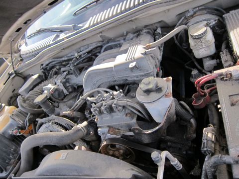 1991 Ford LTD Crown Victoria - The engine bay of a vehicle is covered in dust and grime, obscuring specific details.