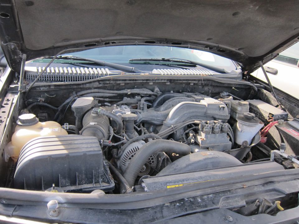 Engine bay with V8 engine, air intake, and battery visible