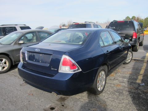 1991 Ford LTD Crown Victoria - A dark blue Ford Fusion is parked in a lot, viewed from the rear.