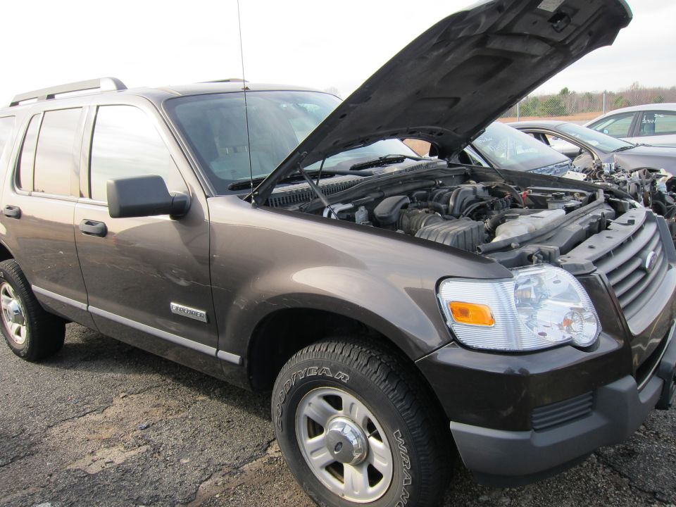 Brown Ford Explorer with hood open, showing engine. Side view