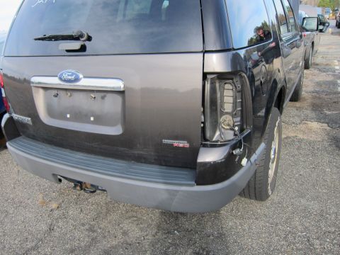 1991 Ford LTD Crown Victoria - This Ford Explorer has a broken taillight and a visible trailer hitch on the rear bumper.