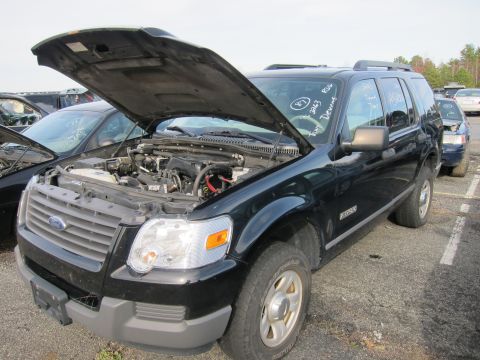 1991 Ford LTD Crown Victoria - A black Ford Explorer is parked in a lot with its hood open, revealing the engine compartment.